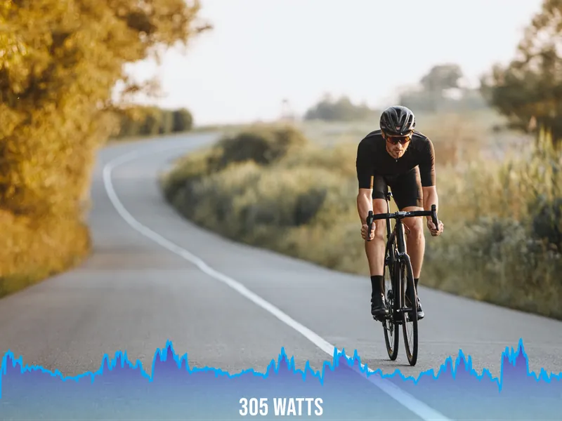 Cyclist on road with 305 watts power graph overlay