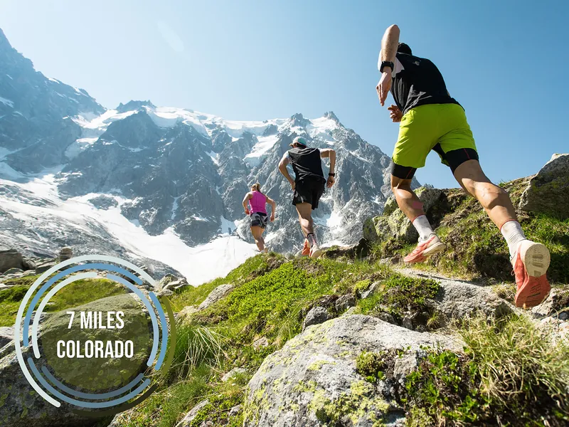 Mountain trail runners with 7 Miles Colorado badge overlay
